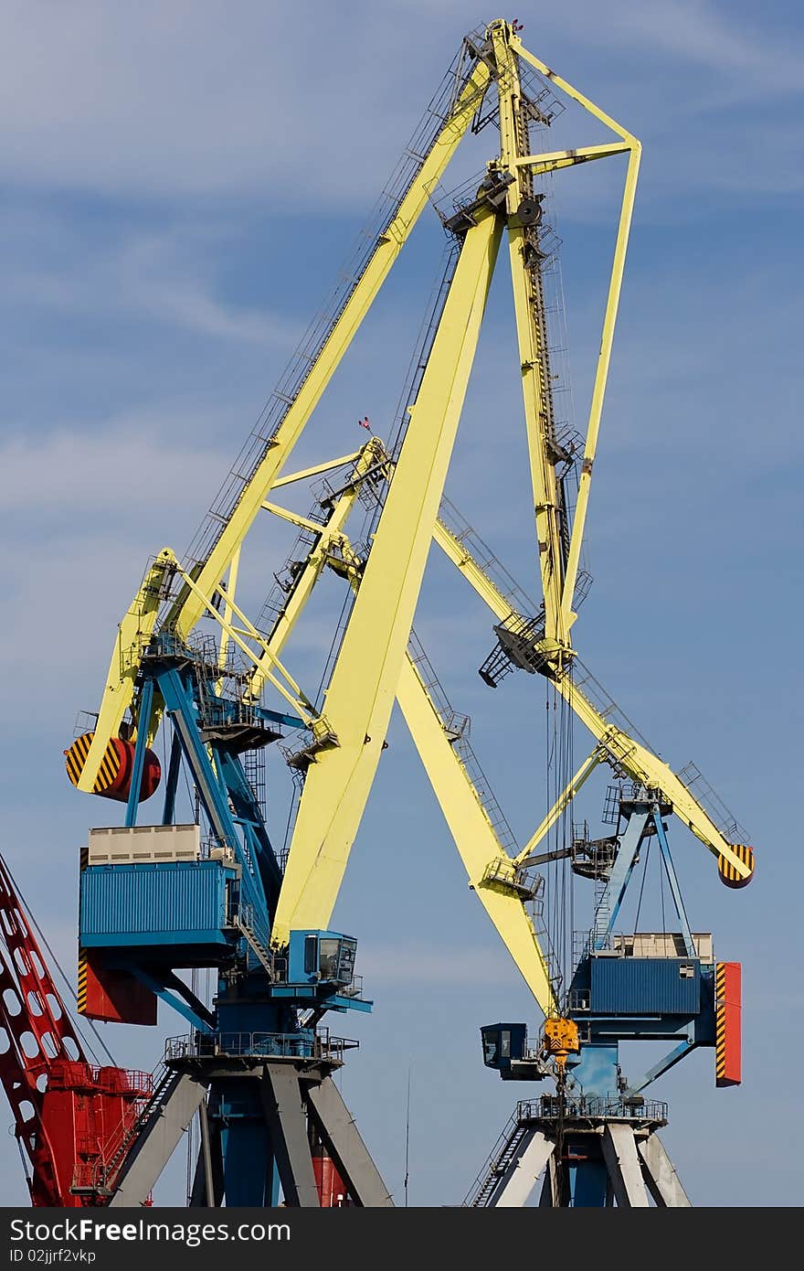 Two huge industrial cranes with blue sky at the background. Two huge industrial cranes with blue sky at the background