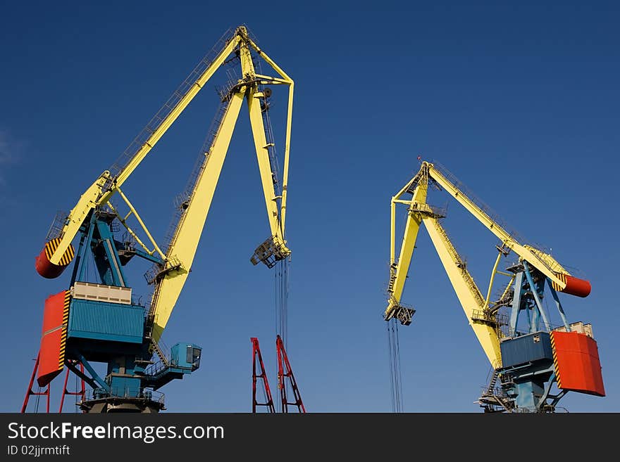 Cranes working under the clear blue sky. Cranes working under the clear blue sky