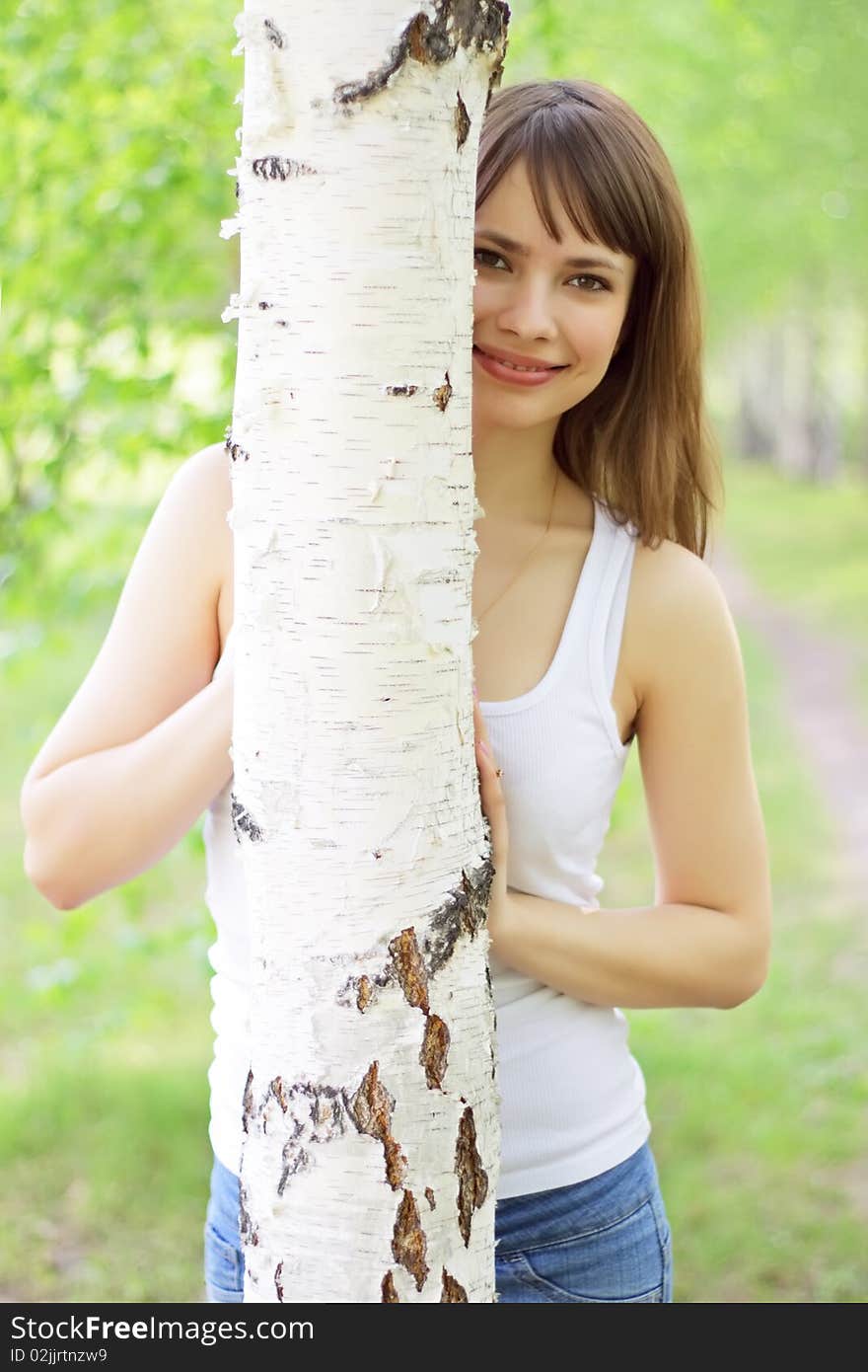 Beautiful girl and birch on a green background