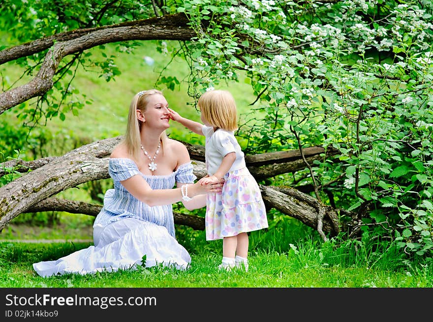 Mother And Daughter In Blooming Garden