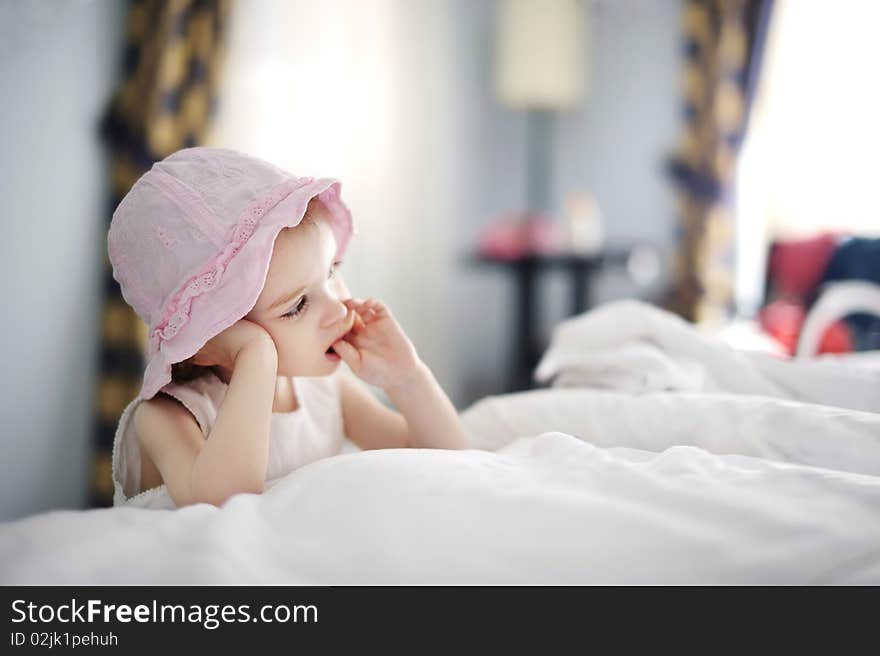 Thoughtful toddler girl in nice pink hat