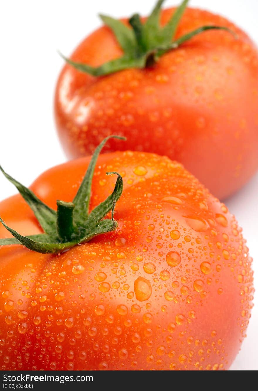 Close-up photo of two tomatoes with water drops