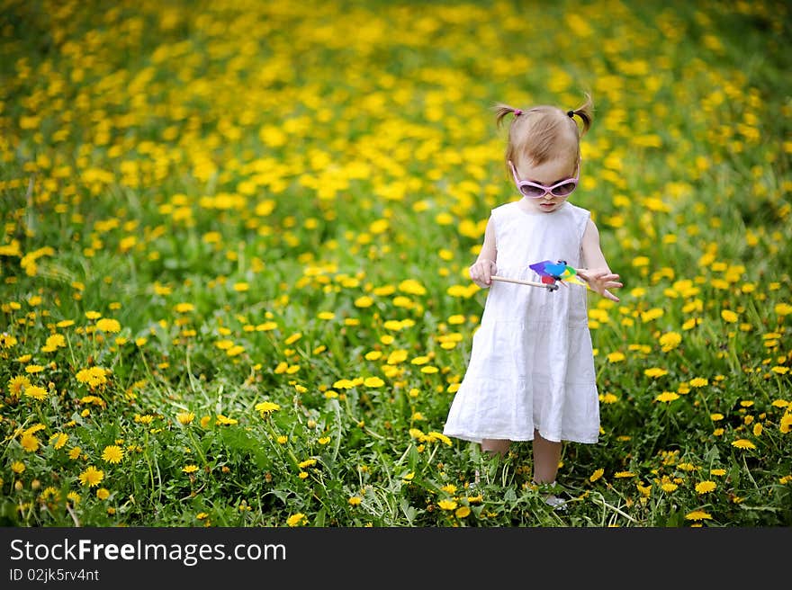 Adorable Girl Standing In Dandelions Field