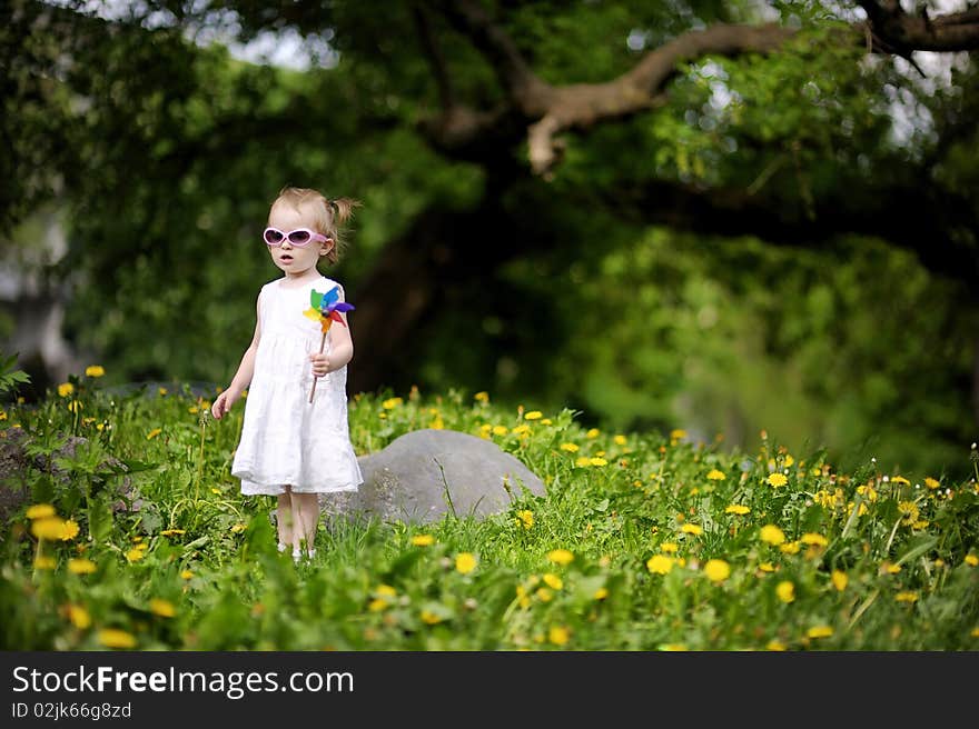 Adorable Girl Standing In Dandelions Field