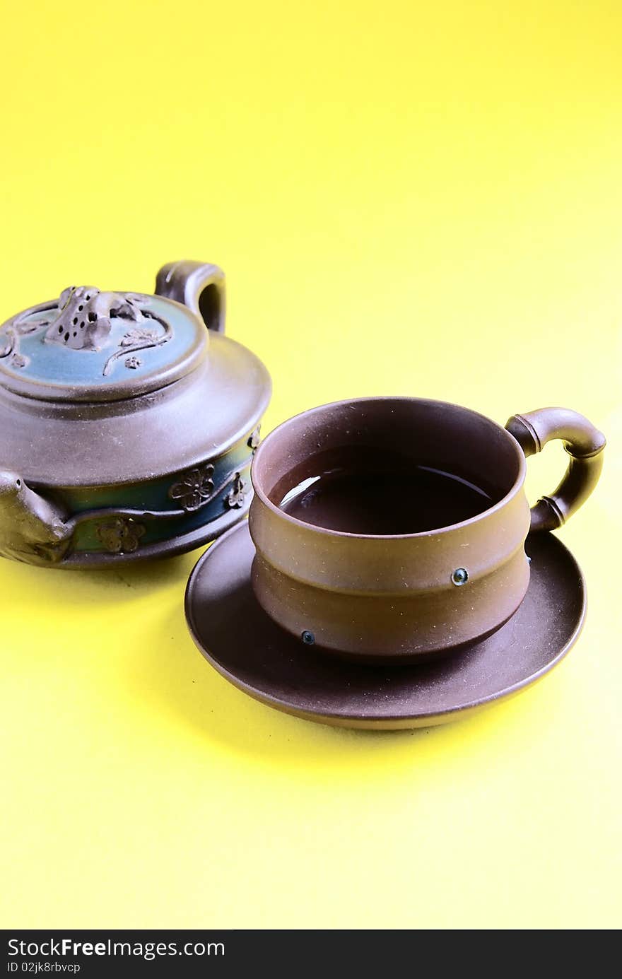 Chinese tea pot and cup isolate on yellow background