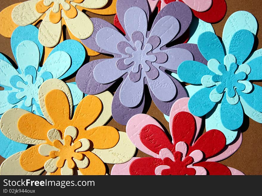 Colorful paper flowers on brown background. Colorful paper flowers on brown background