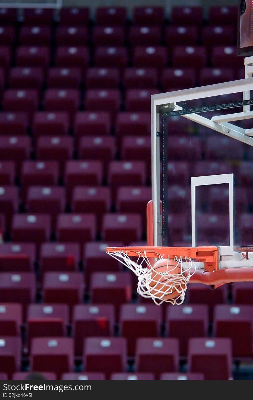 A basketball going through the hoop into the net. A basketball going through the hoop into the net