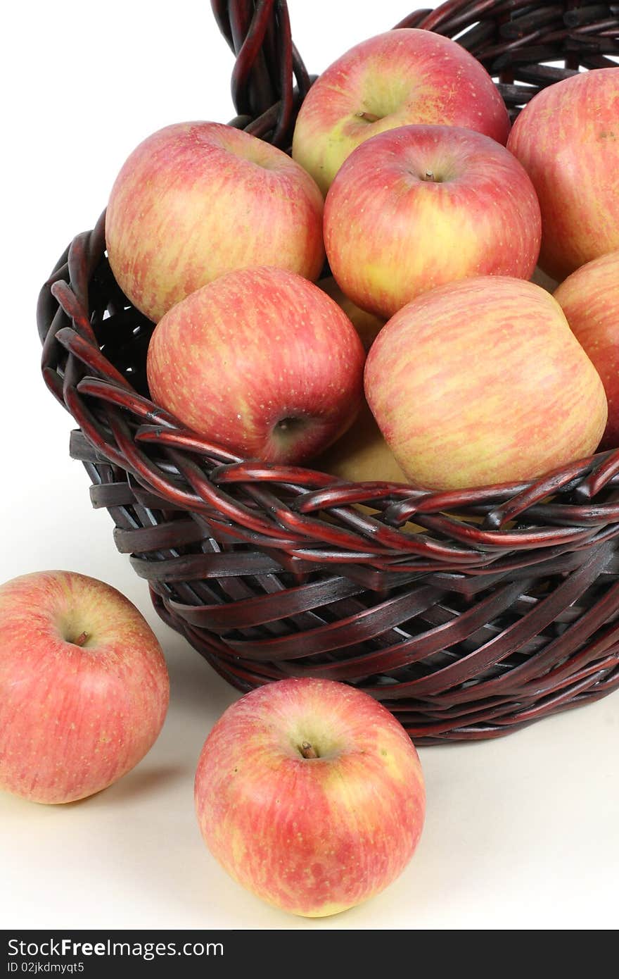 A basket with red ripe apples on white