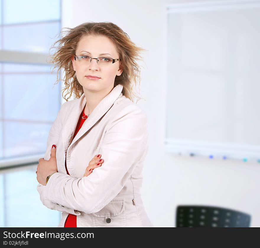 A pretty mature business woman standing in office. A pretty mature business woman standing in office