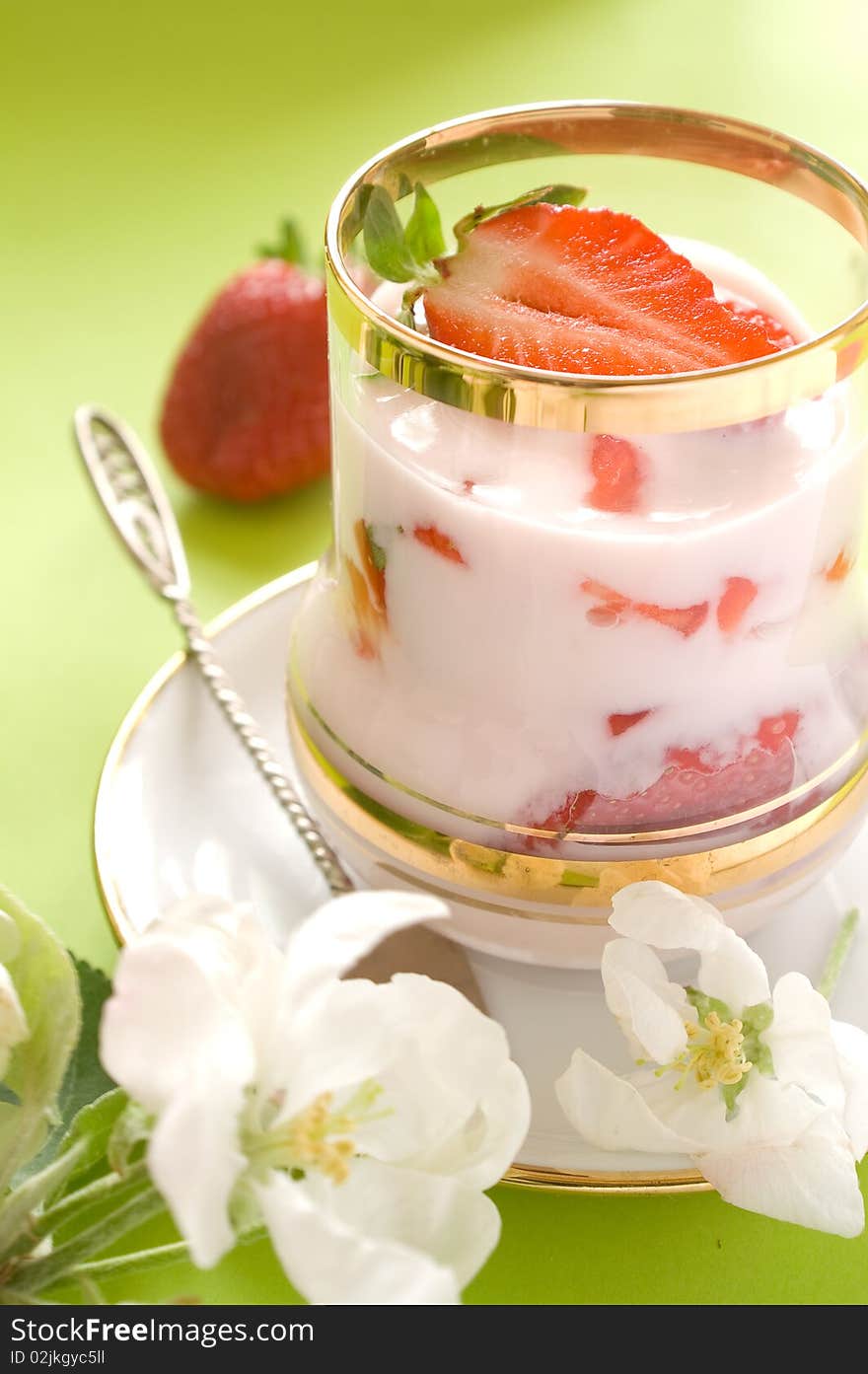 Strawberryyogurt with fresh strawberry in glass. On a 
green backgroundA