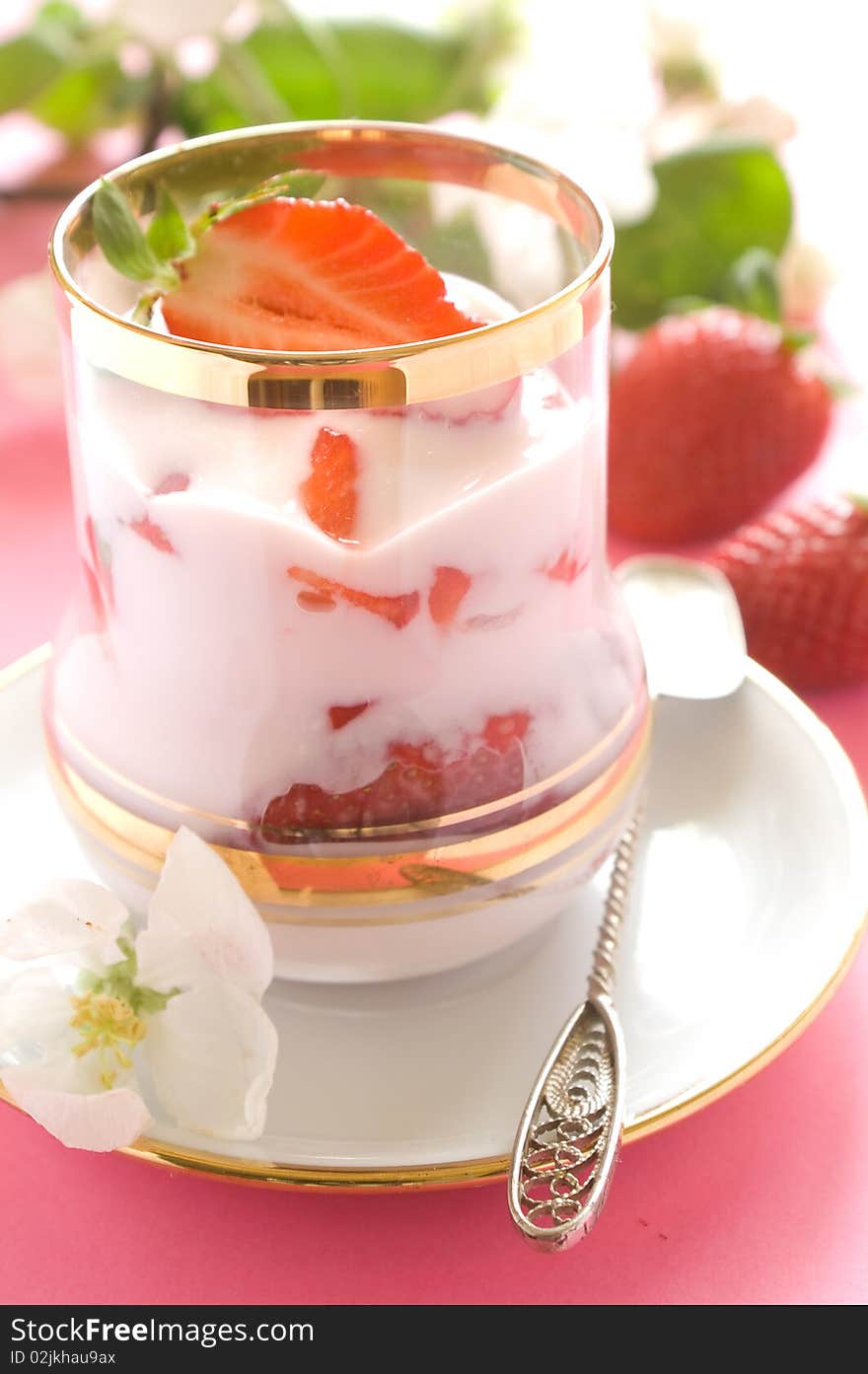 Strawberry yogurt with fresh strawberry in glass. On a pink background