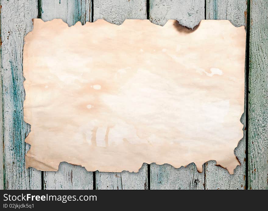 Edged burned paper over panel wood background