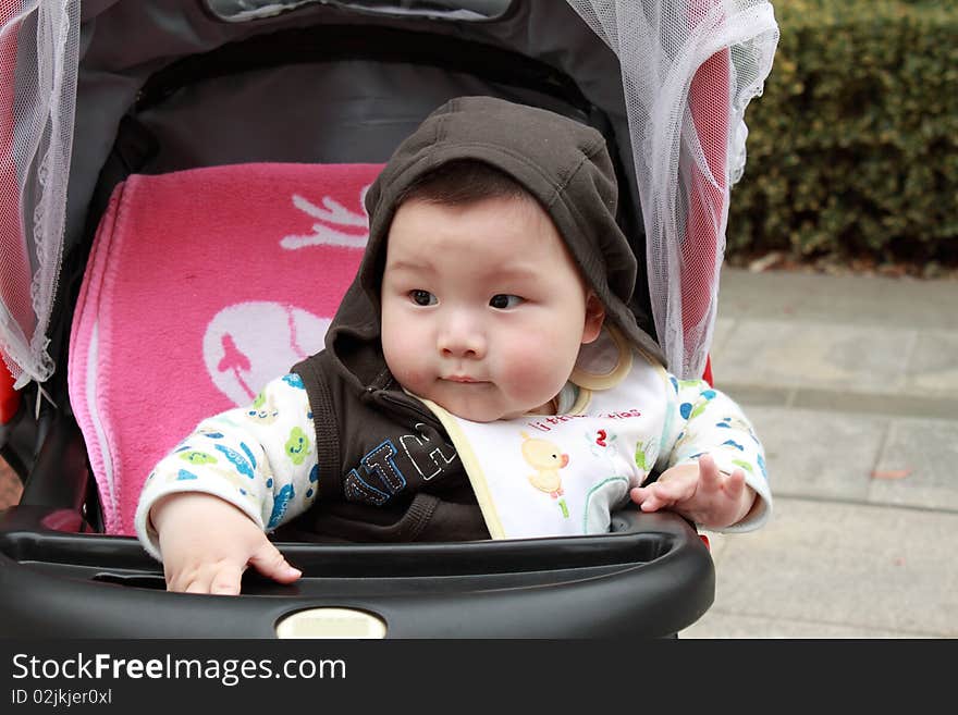 Lovely Chinese baby is sitting in the stroller