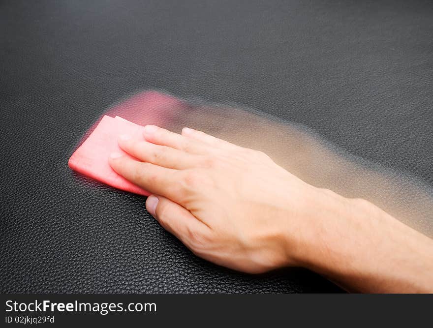 Hand wiping a leather sofa. Hand wiping a leather sofa