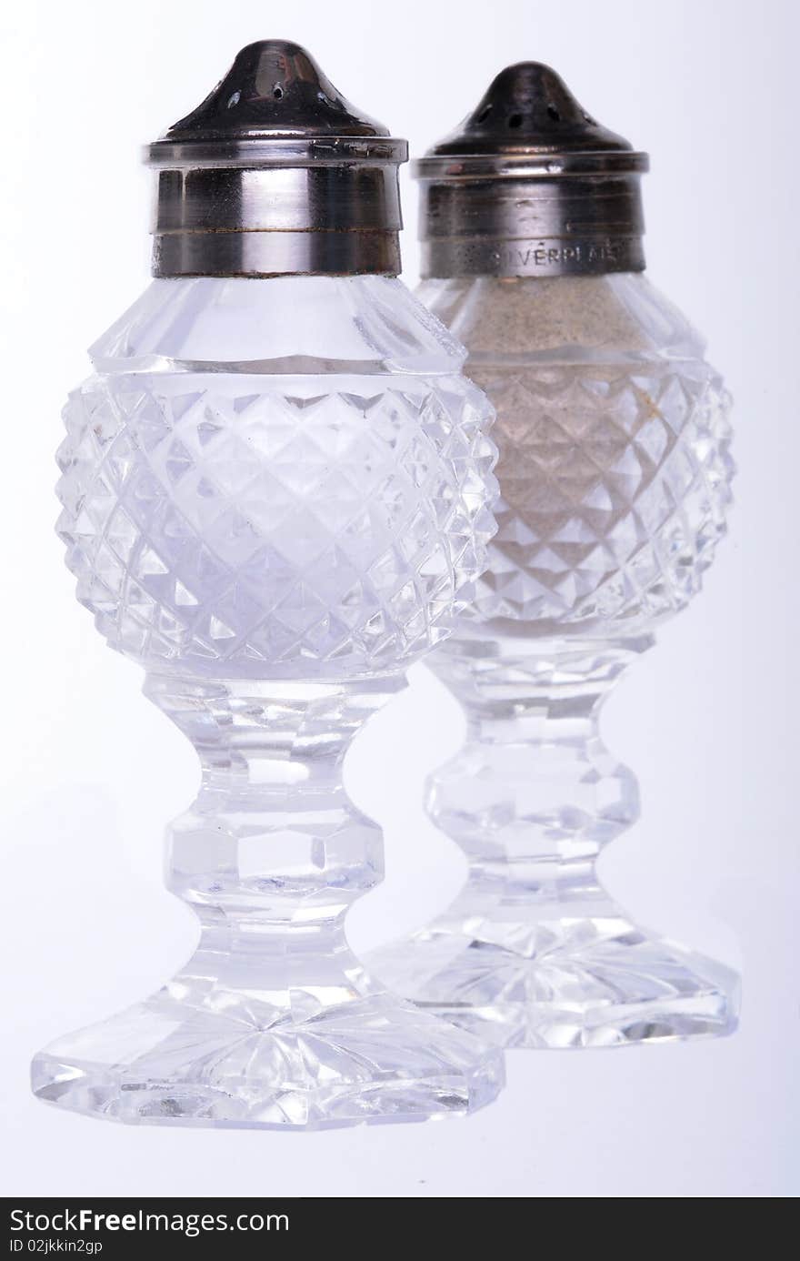 Antique salt and pepper shakers on a white background.