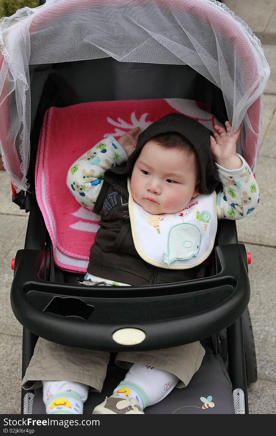 Lovely Chinese baby is sitting in the stroller