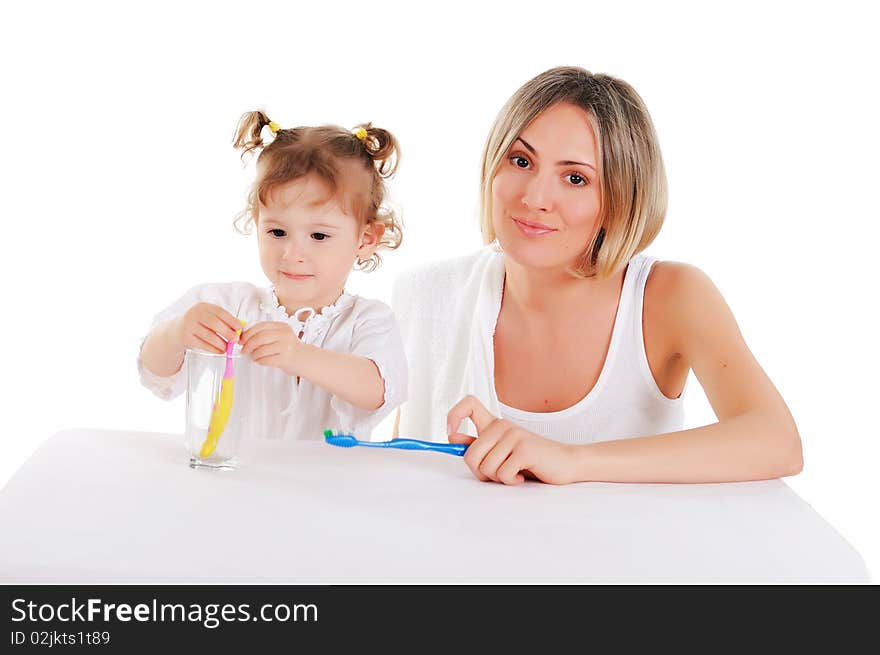 Young mother and her young daughter brush their teeth on a white background