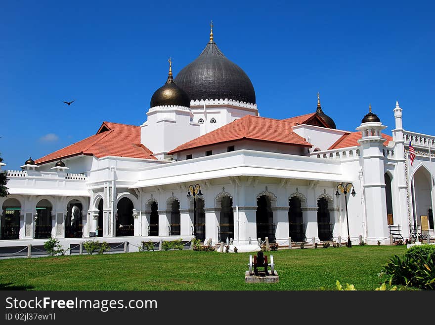 The historic c. 1798 Kapitane Keling Muslim Mosque with its pure white exterior, orange roofs, and black onion domes in Georgetown, Penang Island, Malaysia - Xu Lei Photo. The historic c. 1798 Kapitane Keling Muslim Mosque with its pure white exterior, orange roofs, and black onion domes in Georgetown, Penang Island, Malaysia - Xu Lei Photo.