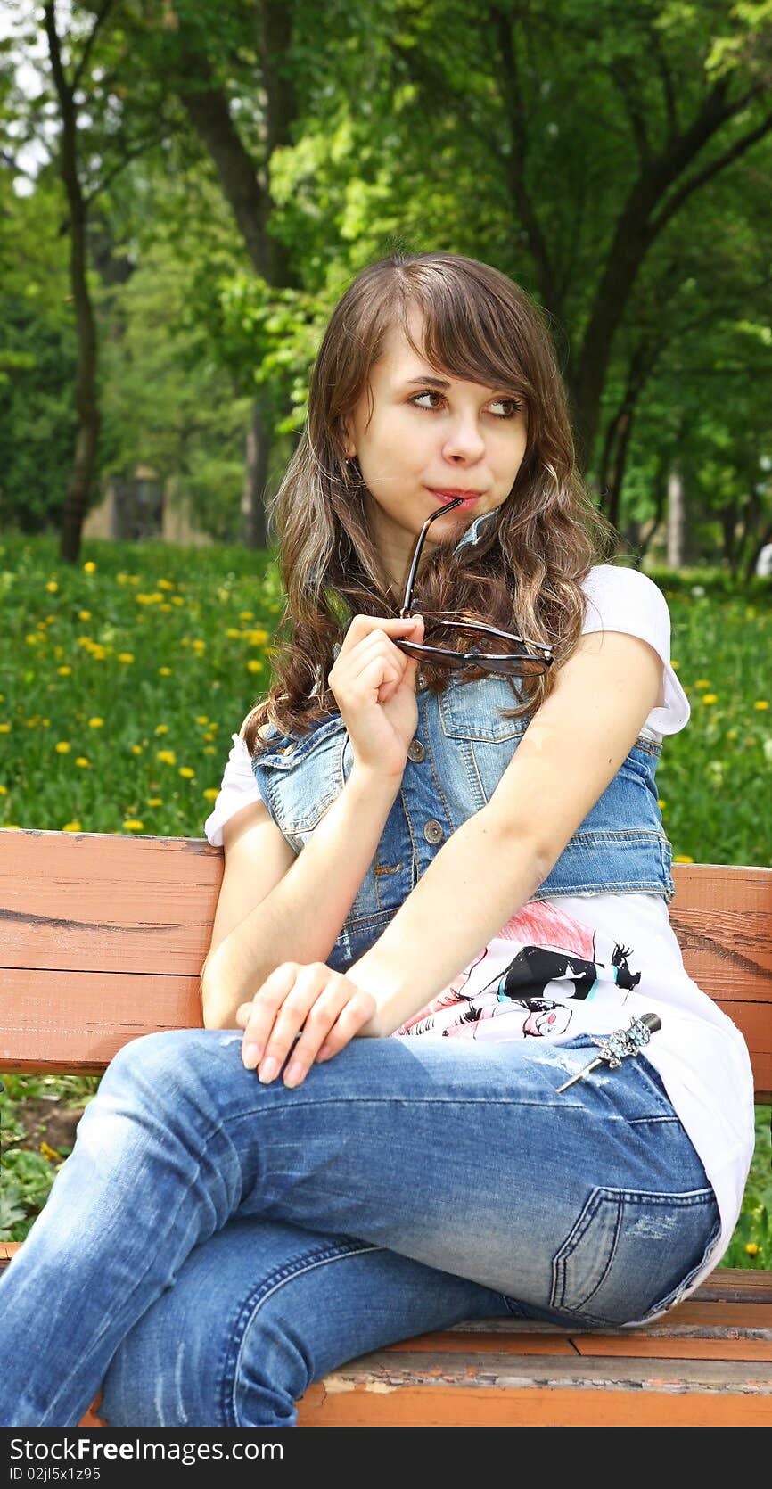 Pretty girl sitting on the bench in the park