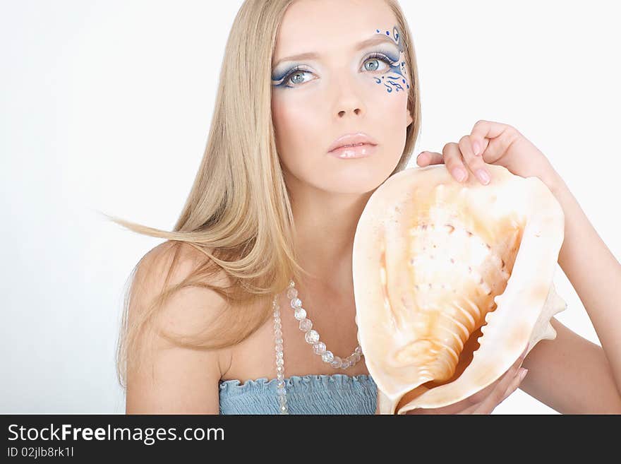 A girl with a seashell in his hands, with a sea of