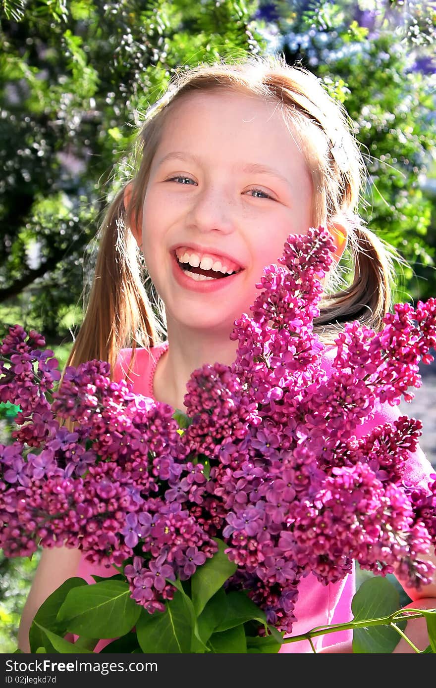 Young girl with lilac flowers on the green background. Young girl with lilac flowers on the green background.