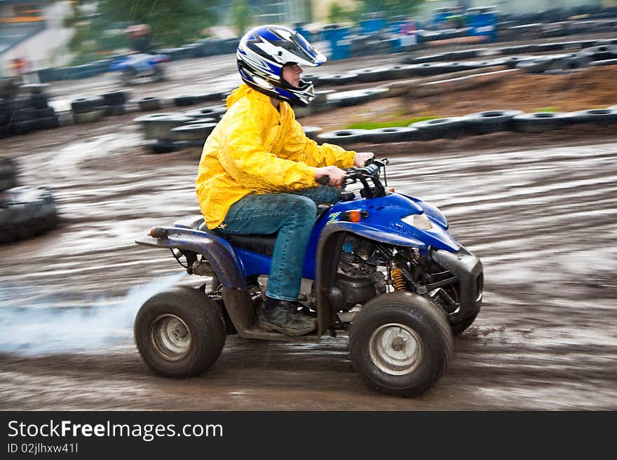 Young boy is fascinated by quart driving and enjoyes it, his face is dirty from mud. Young boy is fascinated by quart driving and enjoyes it, his face is dirty from mud