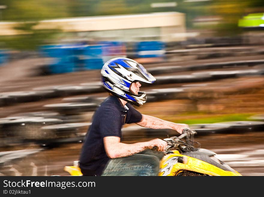 Young boy is fascinated by quart driving and enjoyes it, his face is dirty from mud. Young boy is fascinated by quart driving and enjoyes it, his face is dirty from mud