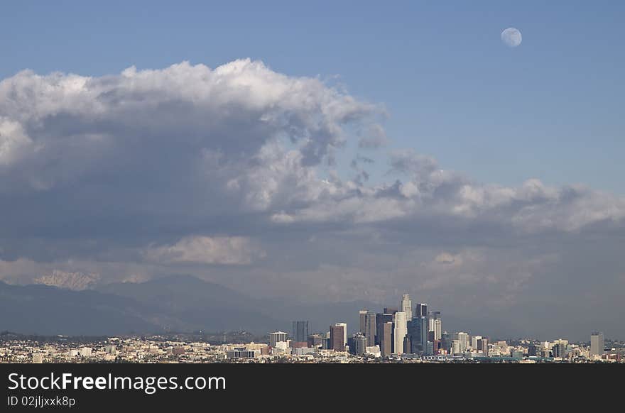 Stormy clouds hoovering over downtown Los Angeles on a late winter afternoon,with a wolfmoon in the sky,and snow covering the san bernardino mountains in the background. Stormy clouds hoovering over downtown Los Angeles on a late winter afternoon,with a wolfmoon in the sky,and snow covering the san bernardino mountains in the background.