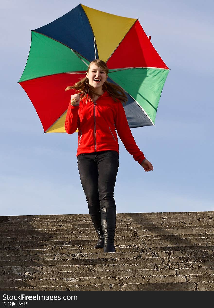 Happy girl with a colorful umbrella down the stairs. Happy girl with a colorful umbrella down the stairs