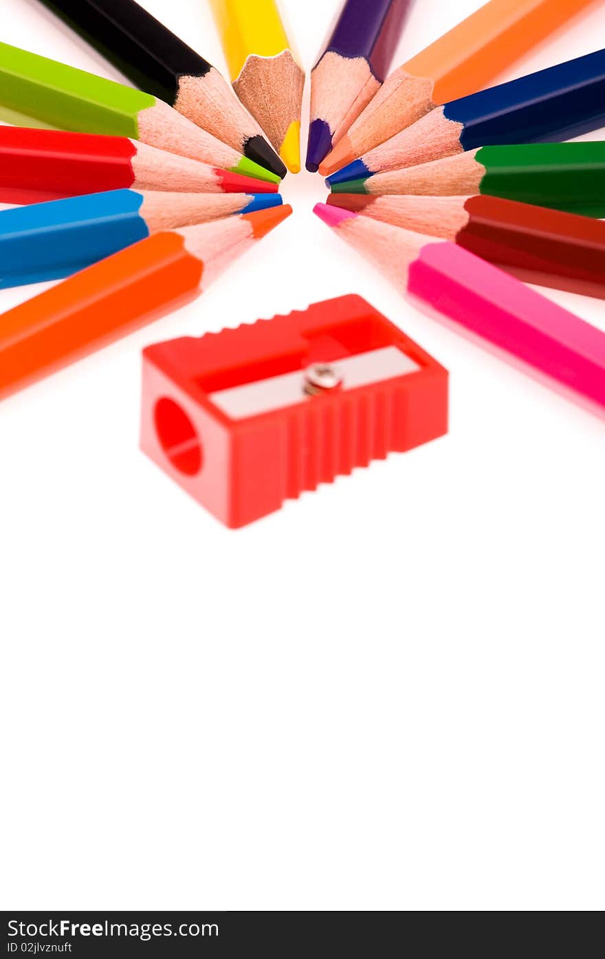 Close-up image of multicolor pencils and red sharpener isolated on white background