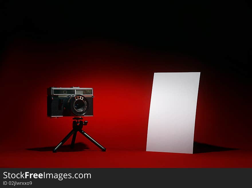 Retro camera and portrait blank photo on black and red background. Retro camera and portrait blank photo on black and red background.