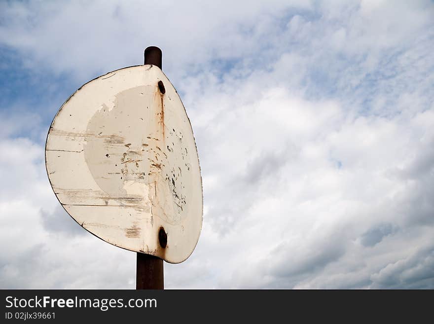 Old crooked prohibition sign in front of clouded sky. Old crooked prohibition sign in front of clouded sky