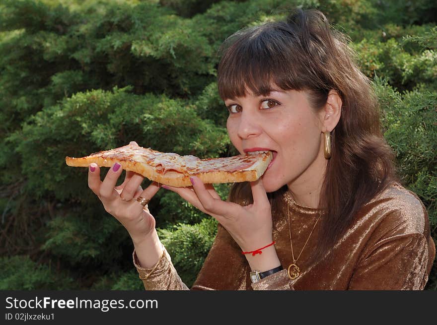 Young beautiful woman eating a big sandwich outdoors. Young beautiful woman eating a big sandwich outdoors.