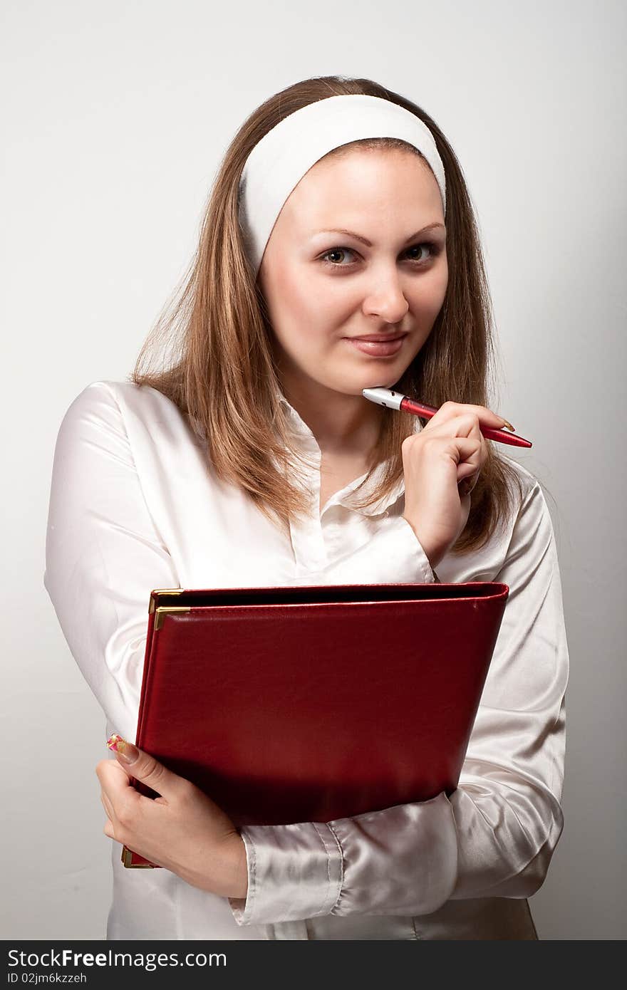 Pretty young nurse writing in red book