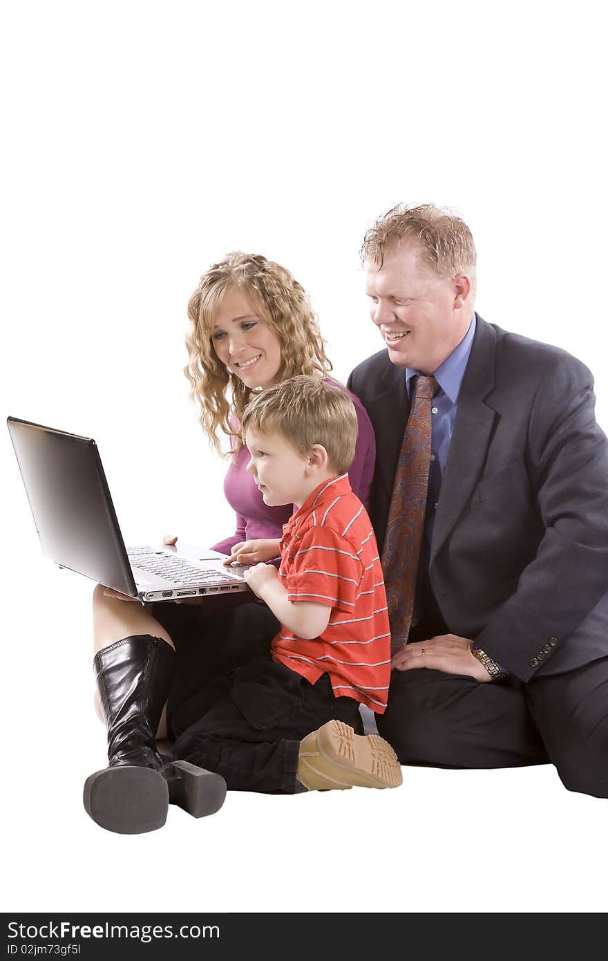 A young boy showing parents things on a computer. A young boy showing parents things on a computer.