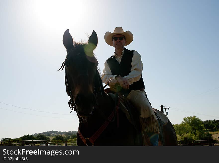 Cowboy riding his horse with the sky in the background