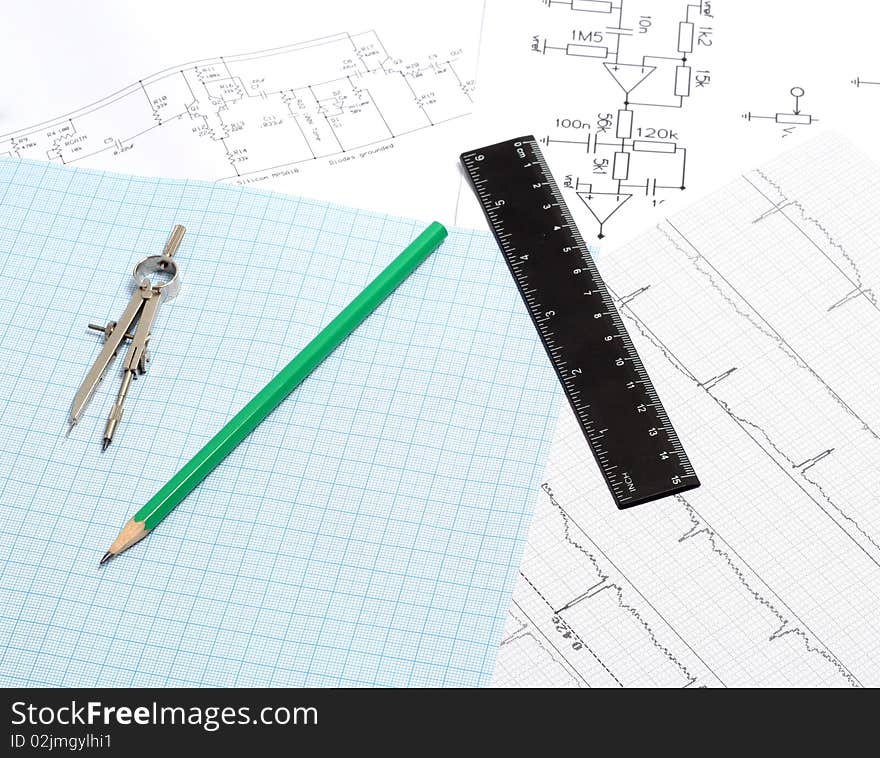 A drafting compass on a graph paper background with, line and green pen