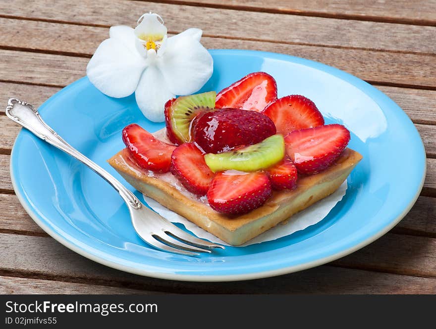 Strawberry cake with kiwi on wood table