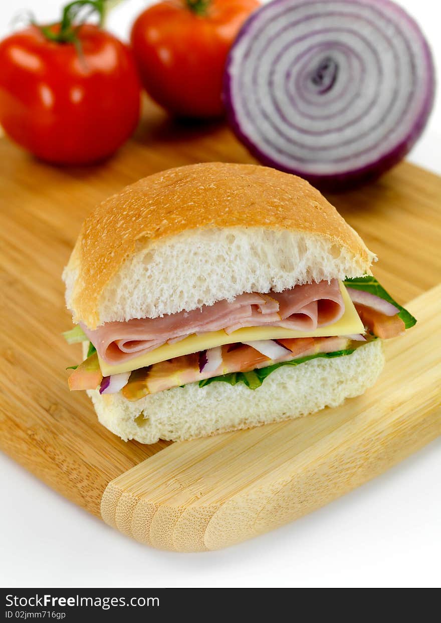 A ham and salad roll on a kitchen bench