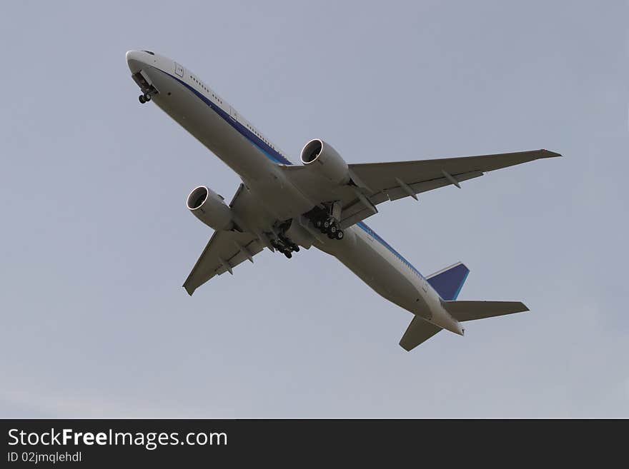 A large two engine commercial jetliner takes off and begins climb out. Landing gear is retracting. A large two engine commercial jetliner takes off and begins climb out. Landing gear is retracting.