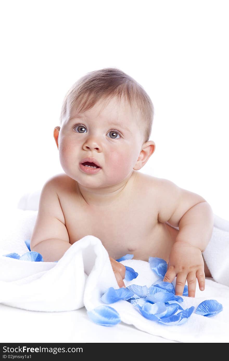 Beautiful baby under a white towel on white background