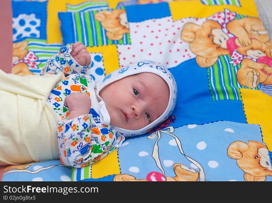 Photo of the beautiful baby lying on bed. Photo of the beautiful baby lying on bed