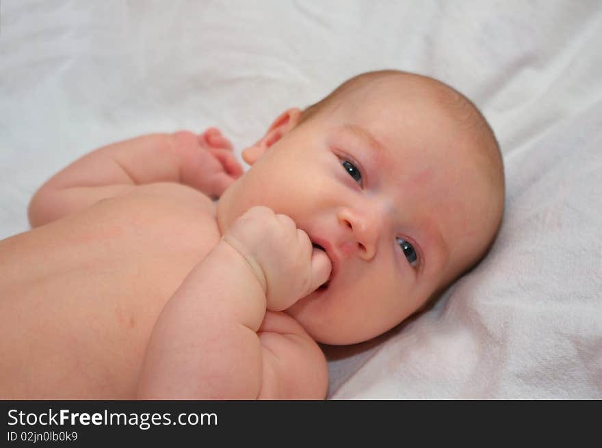 Photo of the beautiful baby lying on bed. Photo of the beautiful baby lying on bed