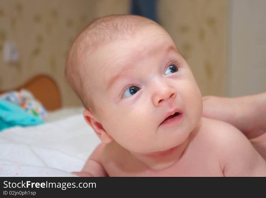 Photo of the beautiful baby lying on bed. Photo of the beautiful baby lying on bed