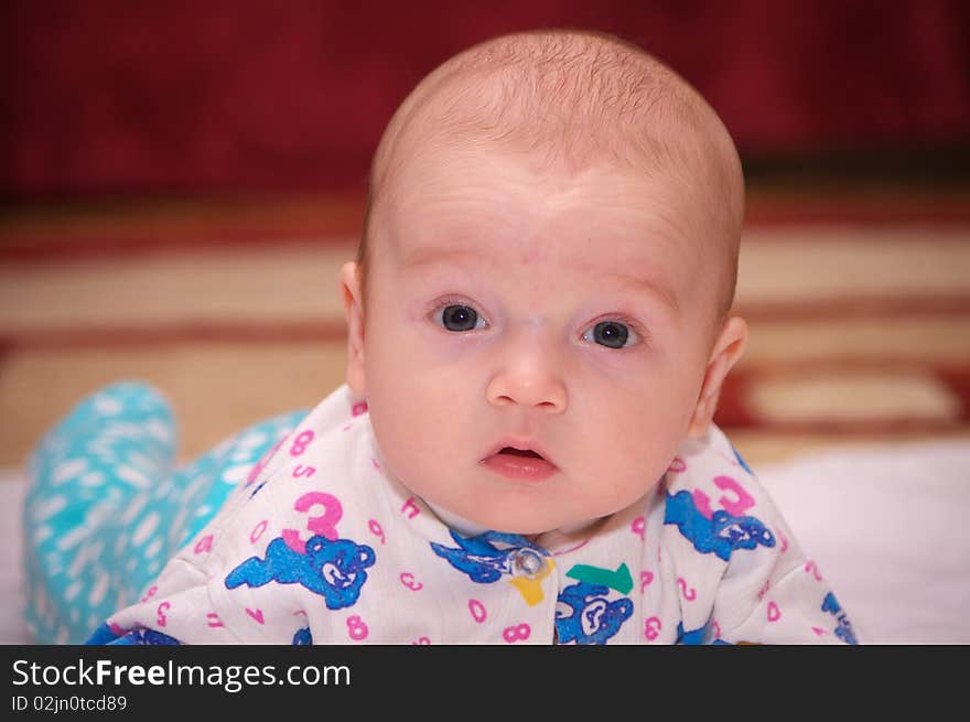 Photo of the beautiful baby lying on bed. Photo of the beautiful baby lying on bed