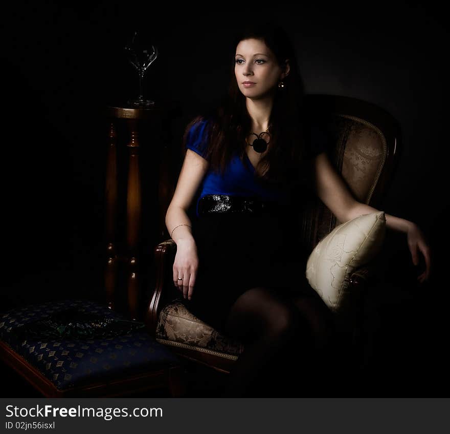 Beautiful young woman sits in a chair. Beautiful young woman sits in a chair