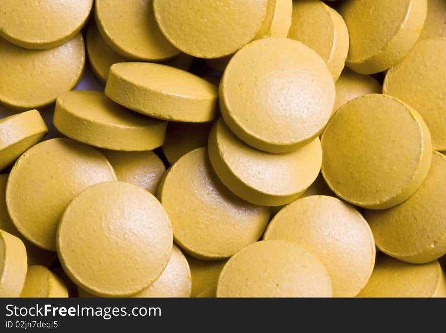 Yellow tablets background.Yellow tablets closeup