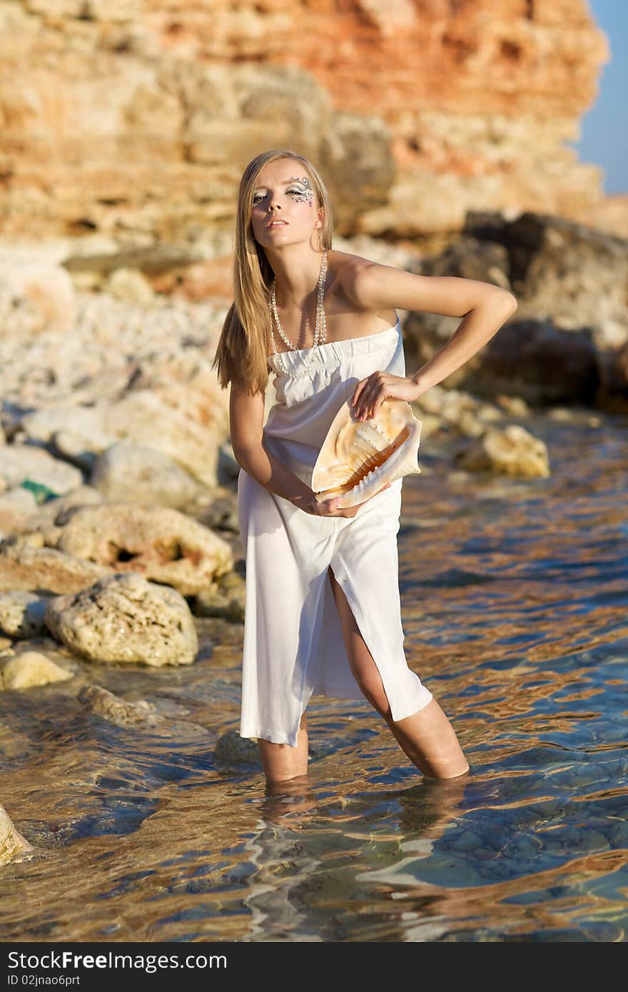 A girl with a seashell in his hands, with a sea of art makeup