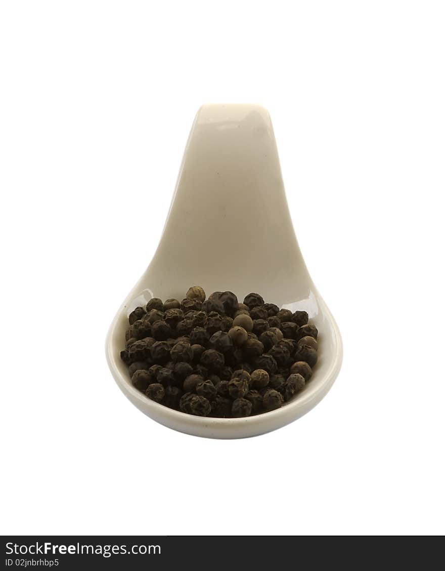 Spoon whit black pepper, isolated in the white background