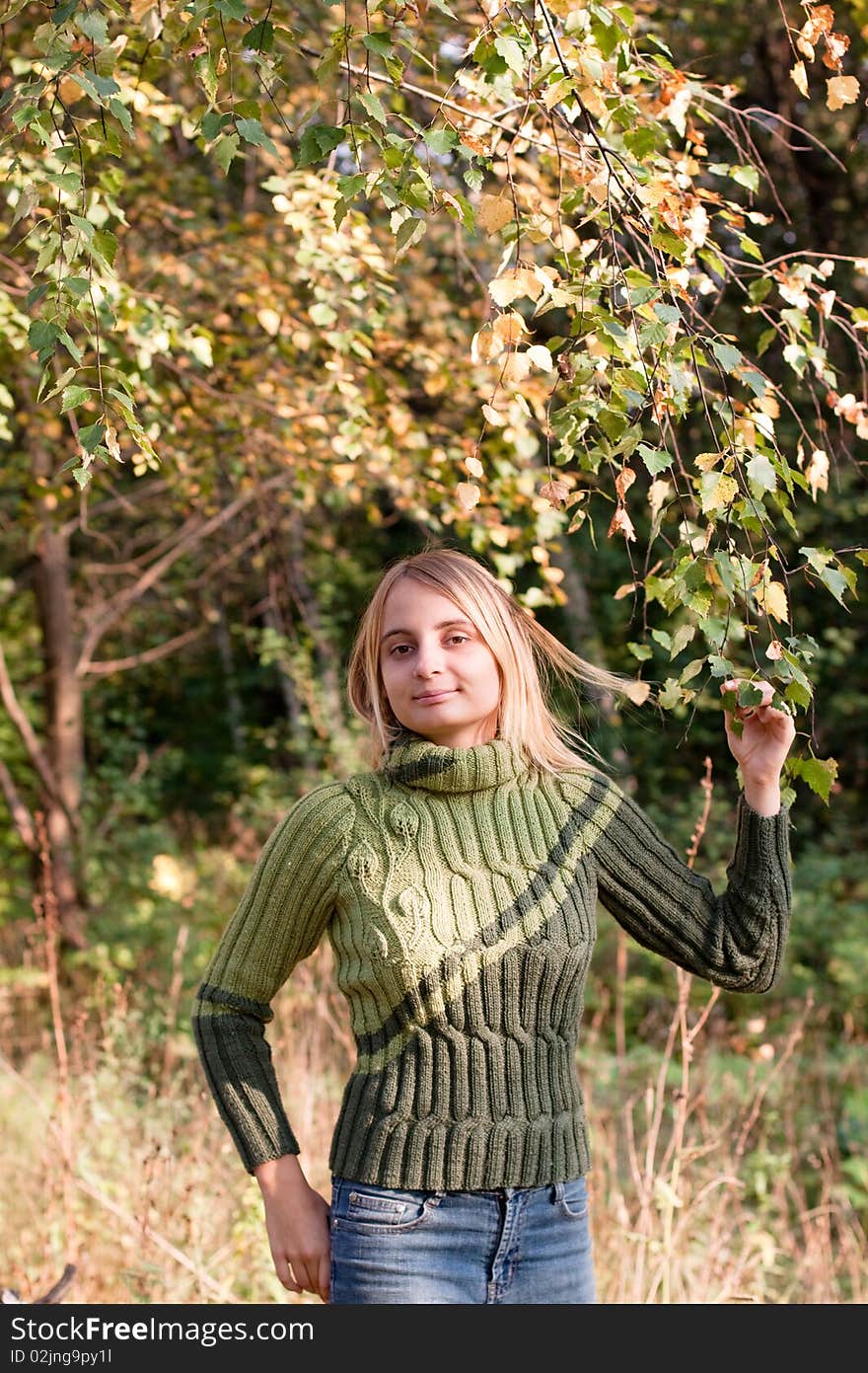 A girl in green pullover in a forest